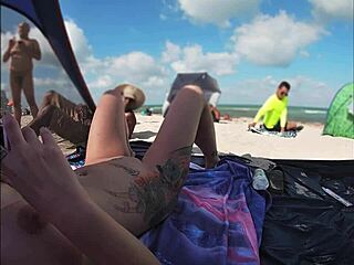 Voyeurismo en la playa con una esposa desnuda y varios hombres mirando