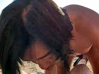 Um homem asiático nu dá um boquete profundo para um homem branco em uma praia do Mediterrâneo